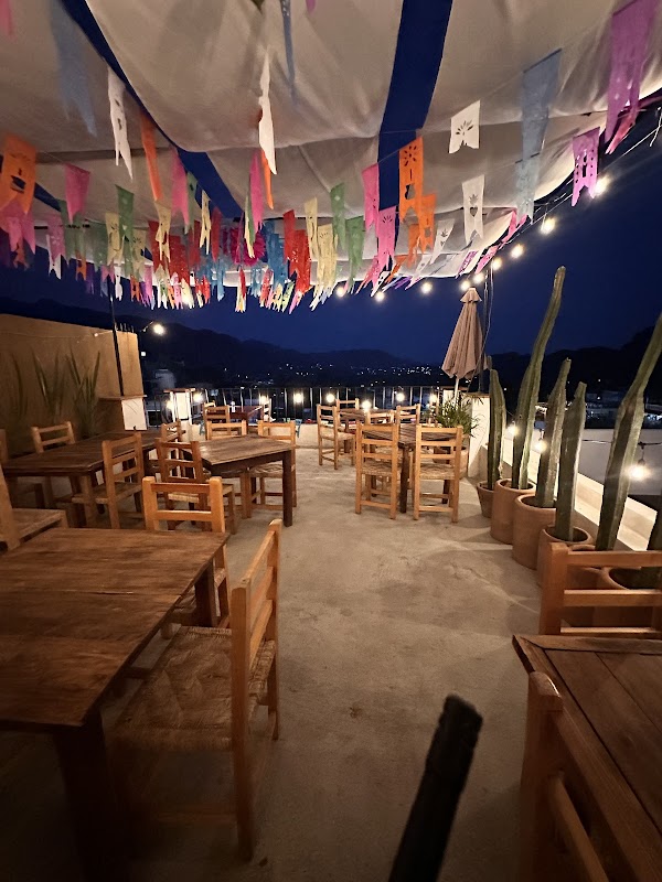 Fachada de Terraza Santa María con su terraza al aire libre y vista al atardecer — captura del exterior y mesas bajo luces