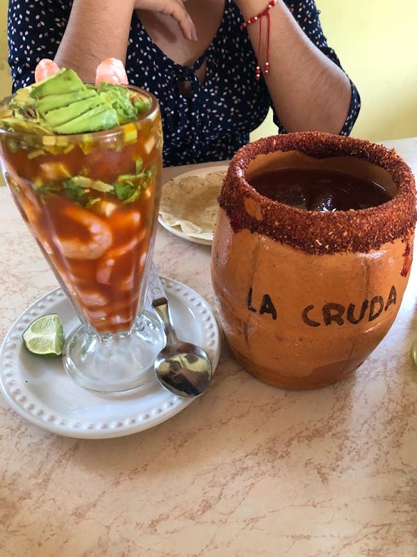 Mesa en El Patio con un plato de chilaquiles y una jarra de agua fresca, ambiente familiar y luz natural.
