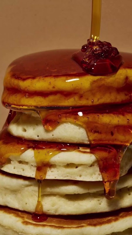 Grand Slam de pancakes con tocino en Pancake Place — pila de pancakes con mantequilla derritiéndose, luz natural del interior