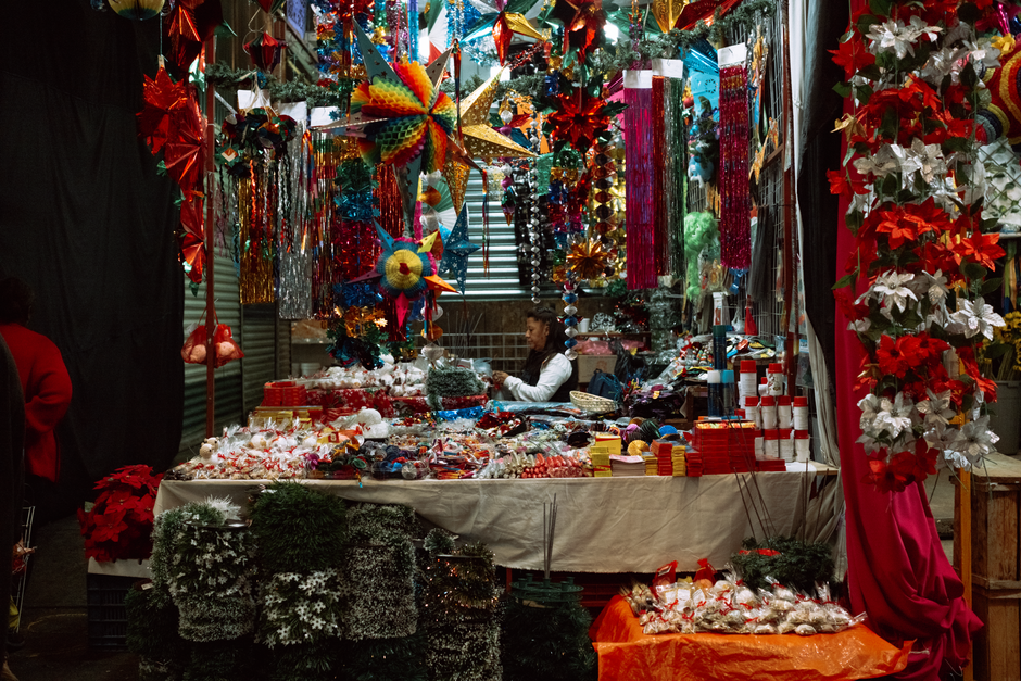Colorful Christmas decorations at a market stall in Mexico City, CDMX, with festive lights and ornaments.