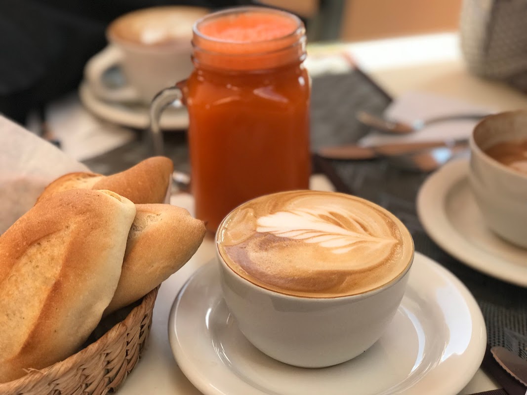 Interior de FIKA CAFÉ mostrando una mesa con juegos de mesa, una taza de té de taro y luz natural filtrada