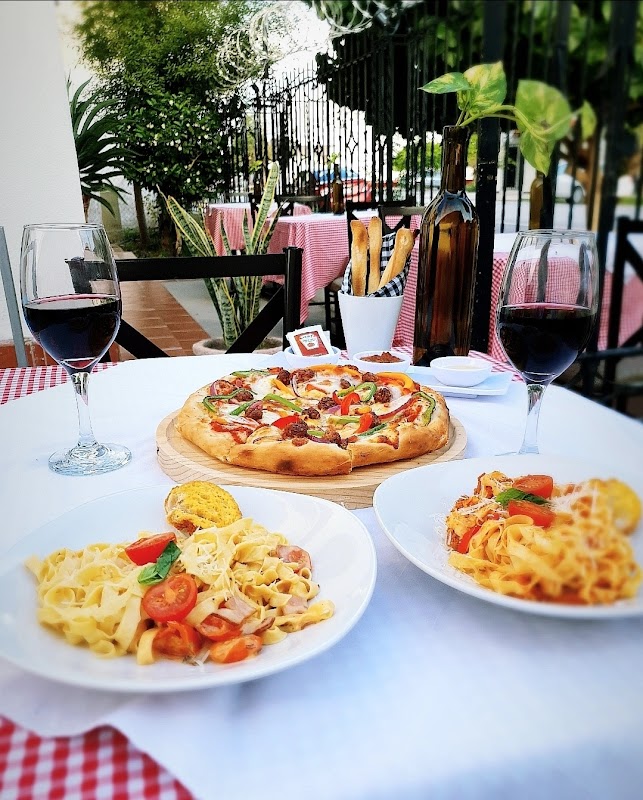 Plato de carbonara y una copa de vino tinto en Trattoria, capturando la presentación y el ambiente casual