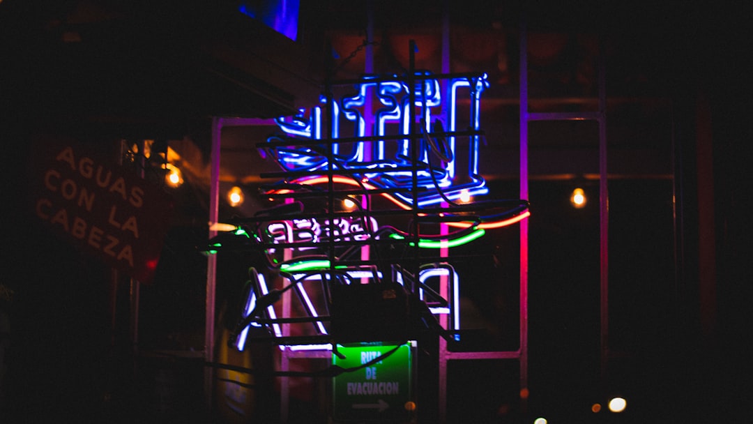 a neon sign is lit up in the dark