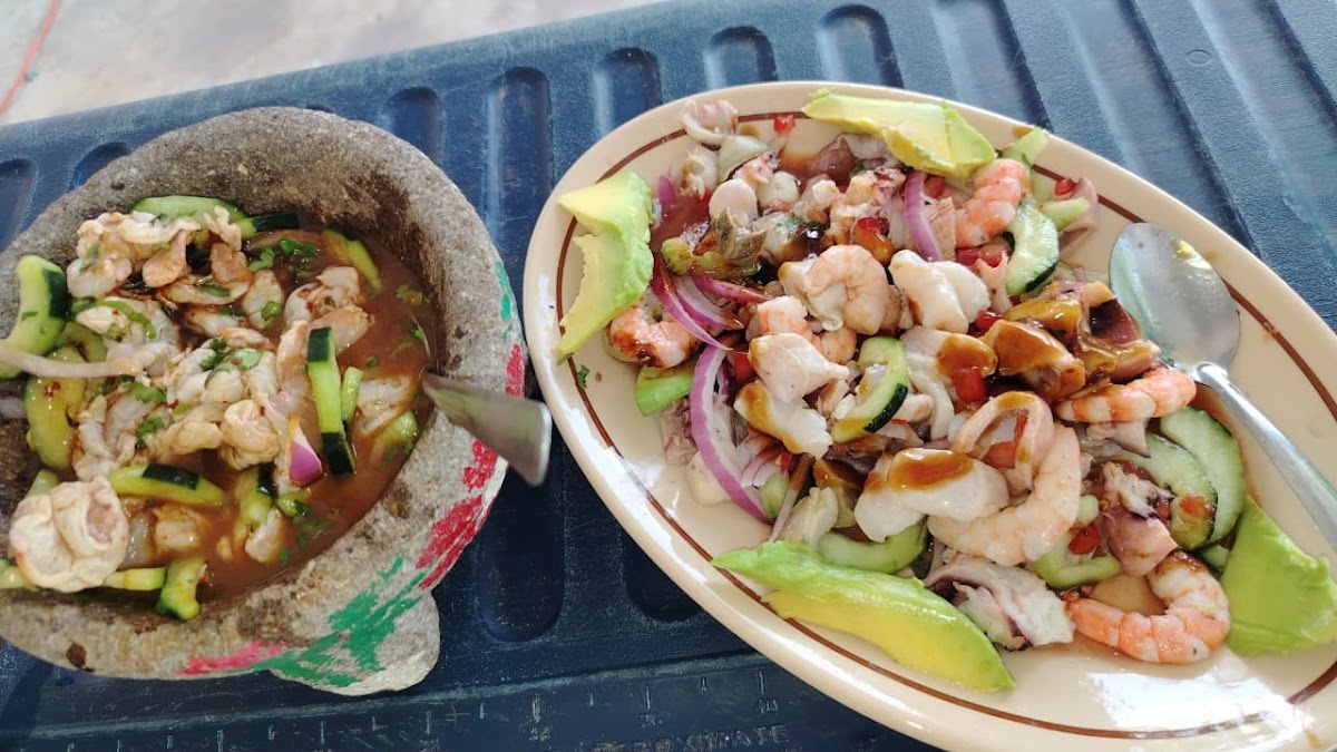 Marisquería El Aguachile – plato de camarones al ajillo en plato de cerámica, fondo de cocina abierta