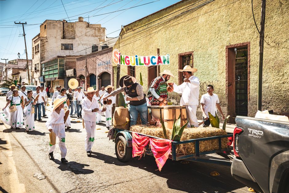 Festive parade in Pachuca de Soto with people in traditional attire celebrating outdoors.