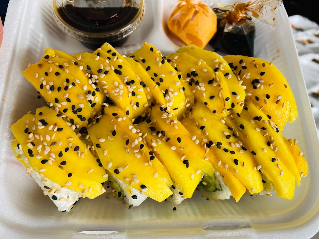 MiSushi Valle — bandeja con rollo de atún y mango, interior con barra de sushi y luces suaves