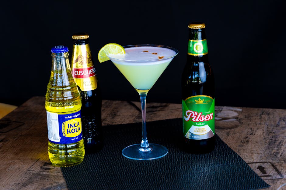 Assorted Peruvian beverages including Pisco Sour and local drinks on wooden table.