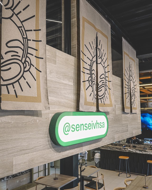Interior de Sensei Sushi Bar con barra de sushi y platos coloridos