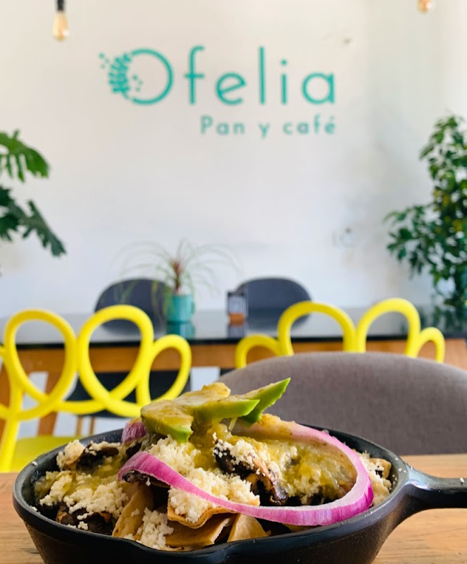 Trattoria Romanelo interior mostrando una pizza napolitana con masa inflada y queso fundido, acompañada de una copa de clericó