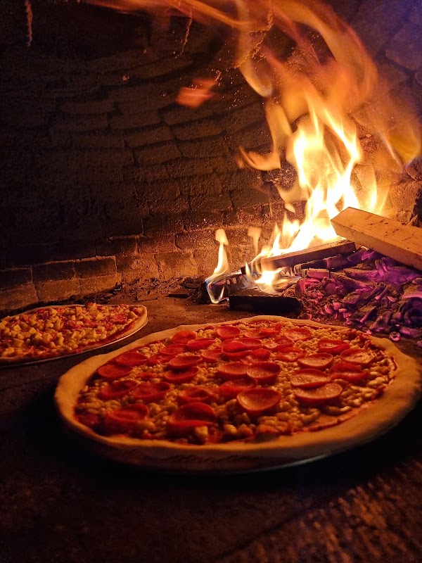 L'artigiano – pizza margherita recién salida del horno, con queso fundido y albahaca, vista desde la mesa