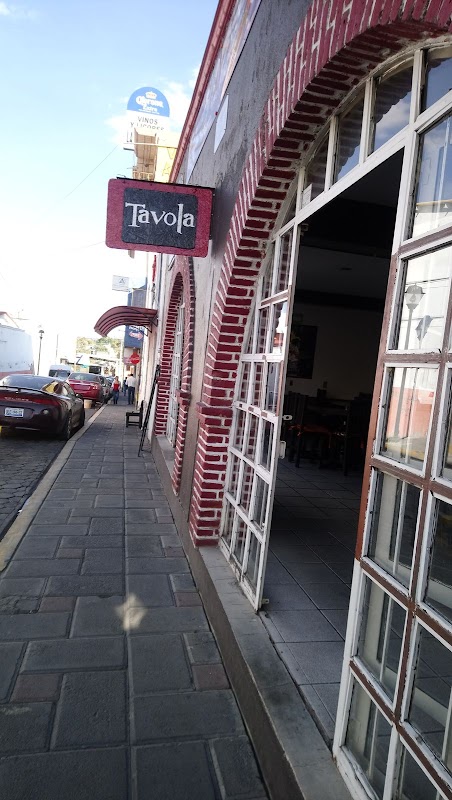 Exterior de Restaurante‑Buffet Tavola con clientes en la zona de desayunos, mostrador de buffet lleno de guisados y señal de precios económicos