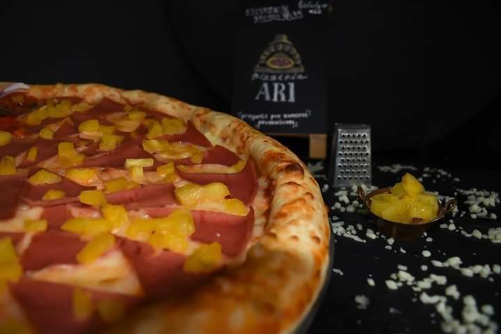 Pizza margarita recién salida del horno en Pizzeria ARI, mostrando la masa crujiente y el queso fundido — foto del horno y la pizza