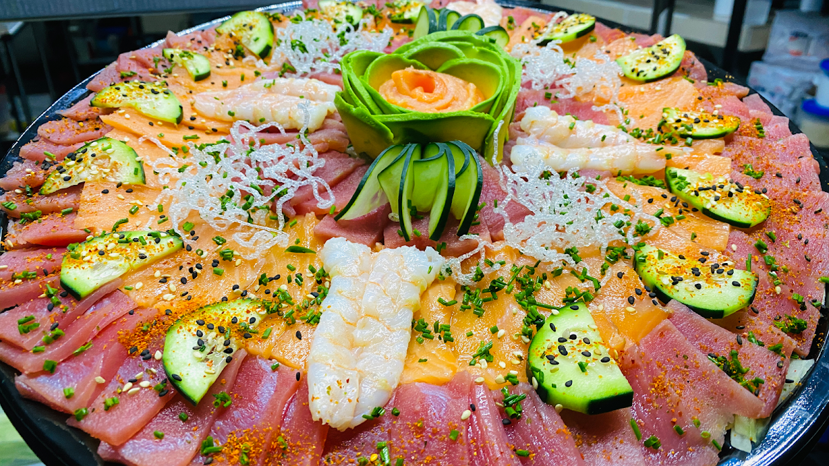 Barra de sushi donde el chef corta nigiri, enfoque en sus manos y cuchillos