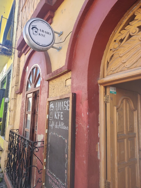 AmaSei K'Fé – Café De Altura — interior iluminado con barra de café y croissant recién horneado en primer plano